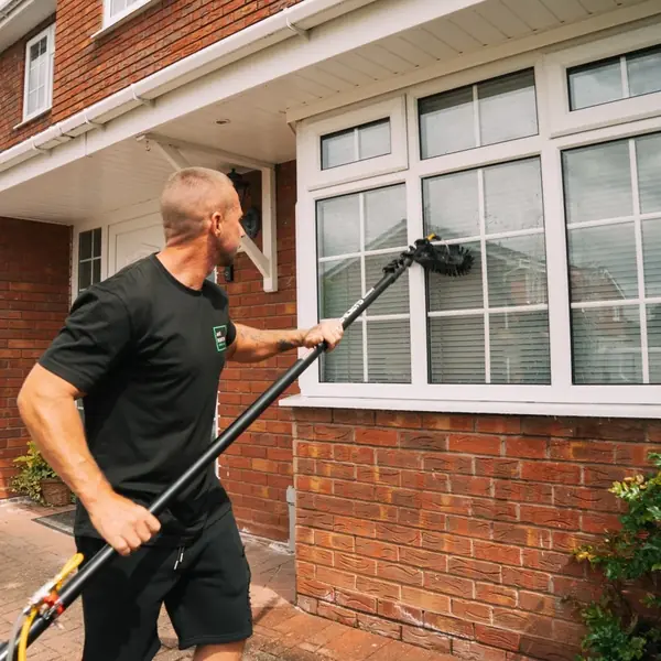 Ant cleaning a ground floor bay window with the pole brush