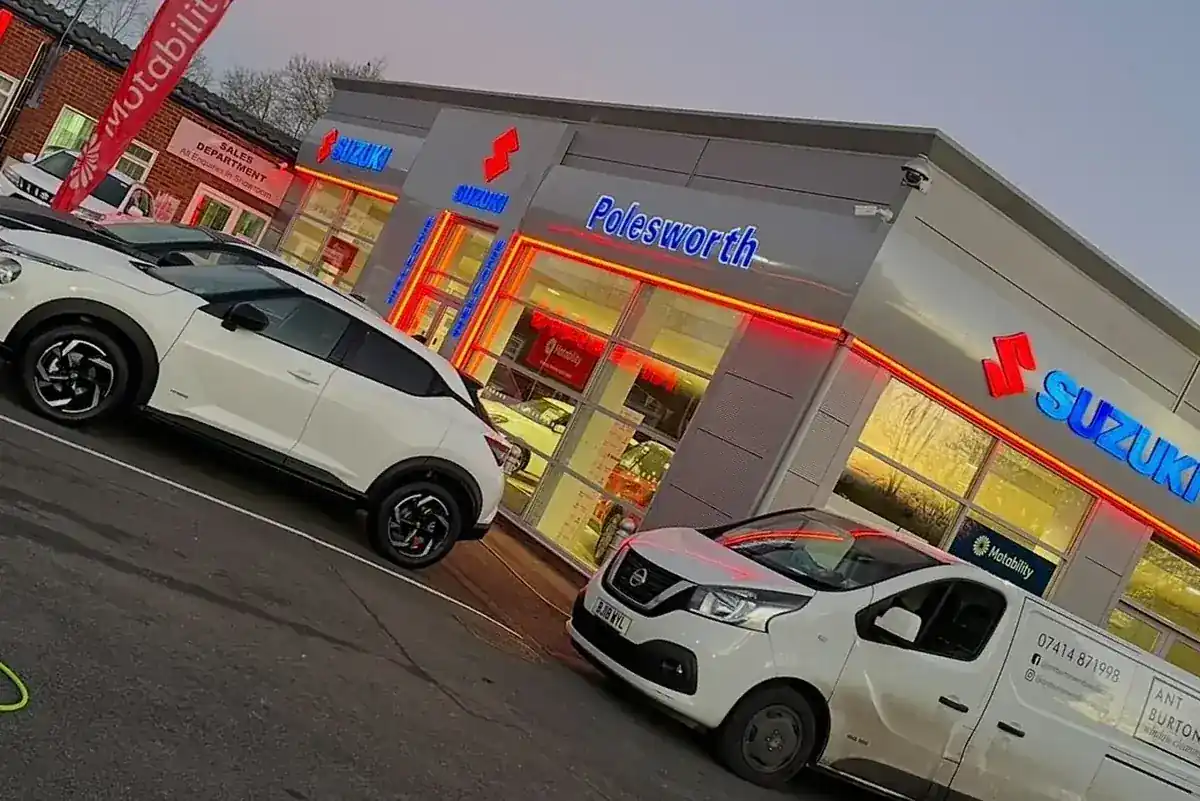 Cleaning the Suzuki and Polesworth Garage showroom frontage at dusk with the neon signage lit